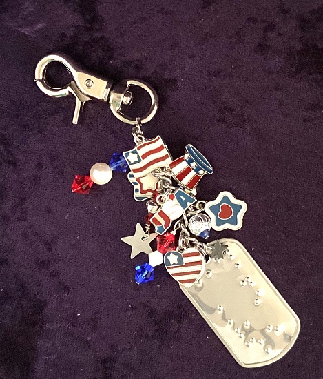 Photo of the Touch of Americana Purse Charm lying on a purple background