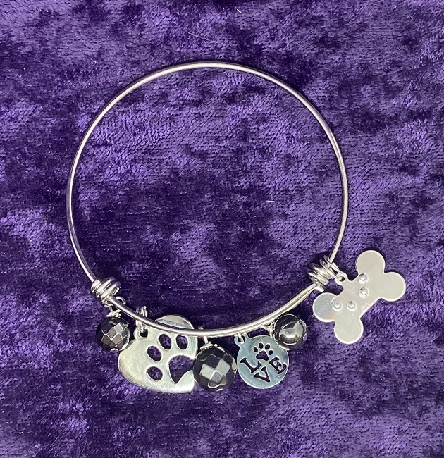 Photo of our Doggy Dangle Bangle on a purple background