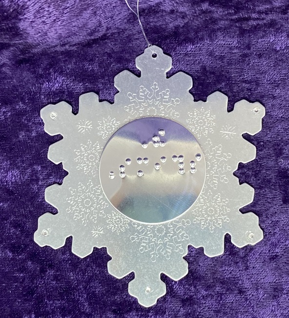 A silvery snowflake ornament with a center disc braille embossed with "The Smiths."